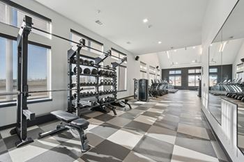 A spacious gym with a variety of equipment and a checkered floor.